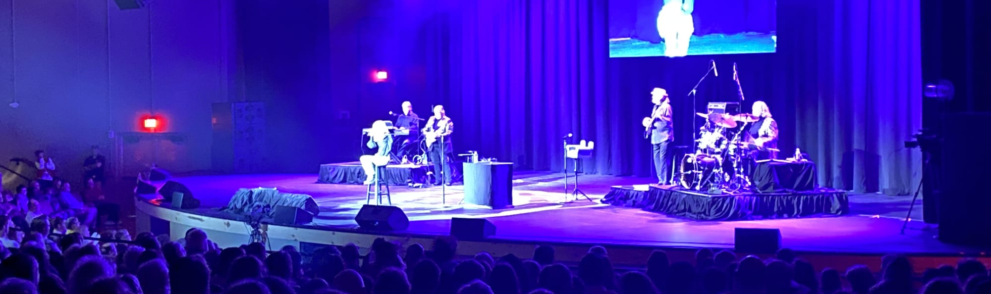 signer on stage in chair washed out by the lights Evansville